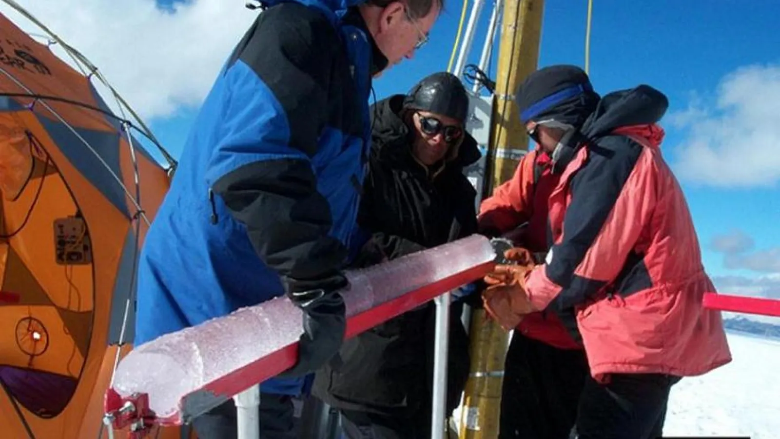 Researchers holding and researching an ice core in Quelccaya, Peru. 2003.