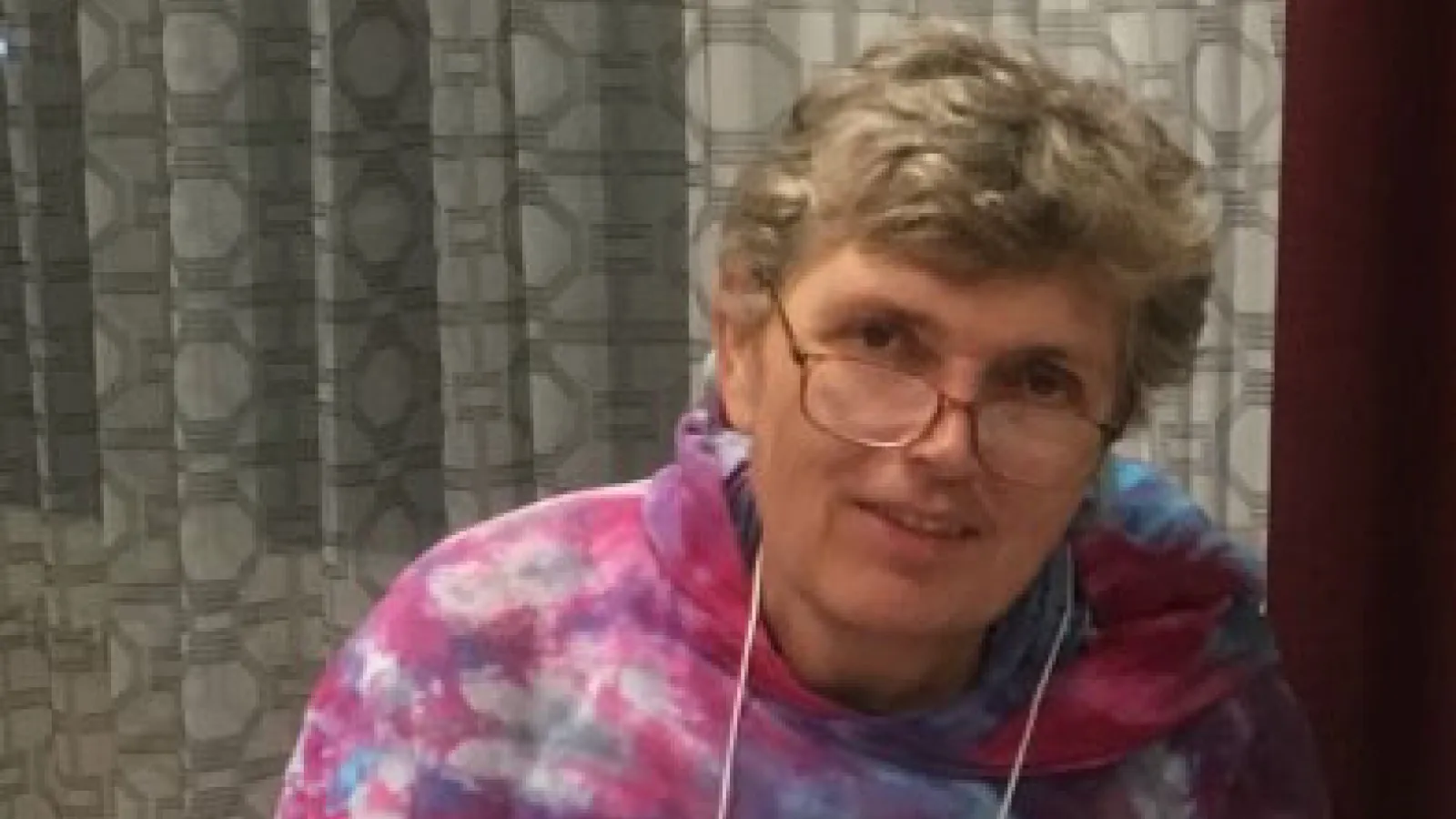 Susan Welch smiling for a photo in a pink and blue top