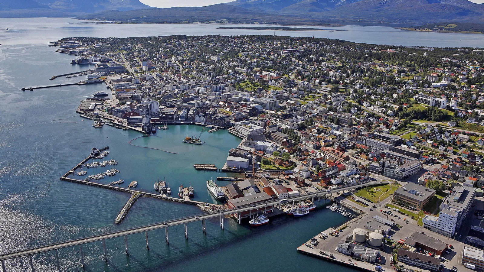 Aerial view of a coastal city and a long bridge next to a body of water.