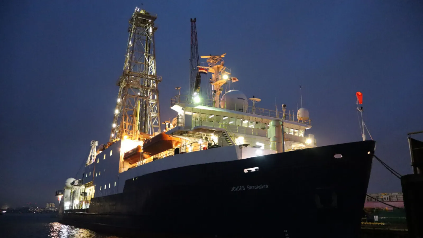 A lit up ship at sea in the night.