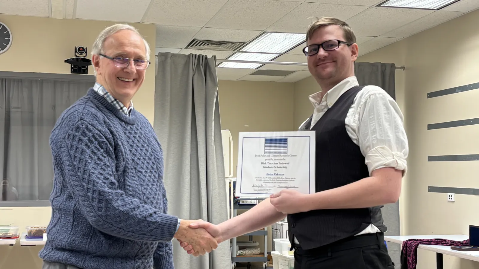 Brian Rakoczy receives award from his advisor, David Bromwich. The two shake hands.