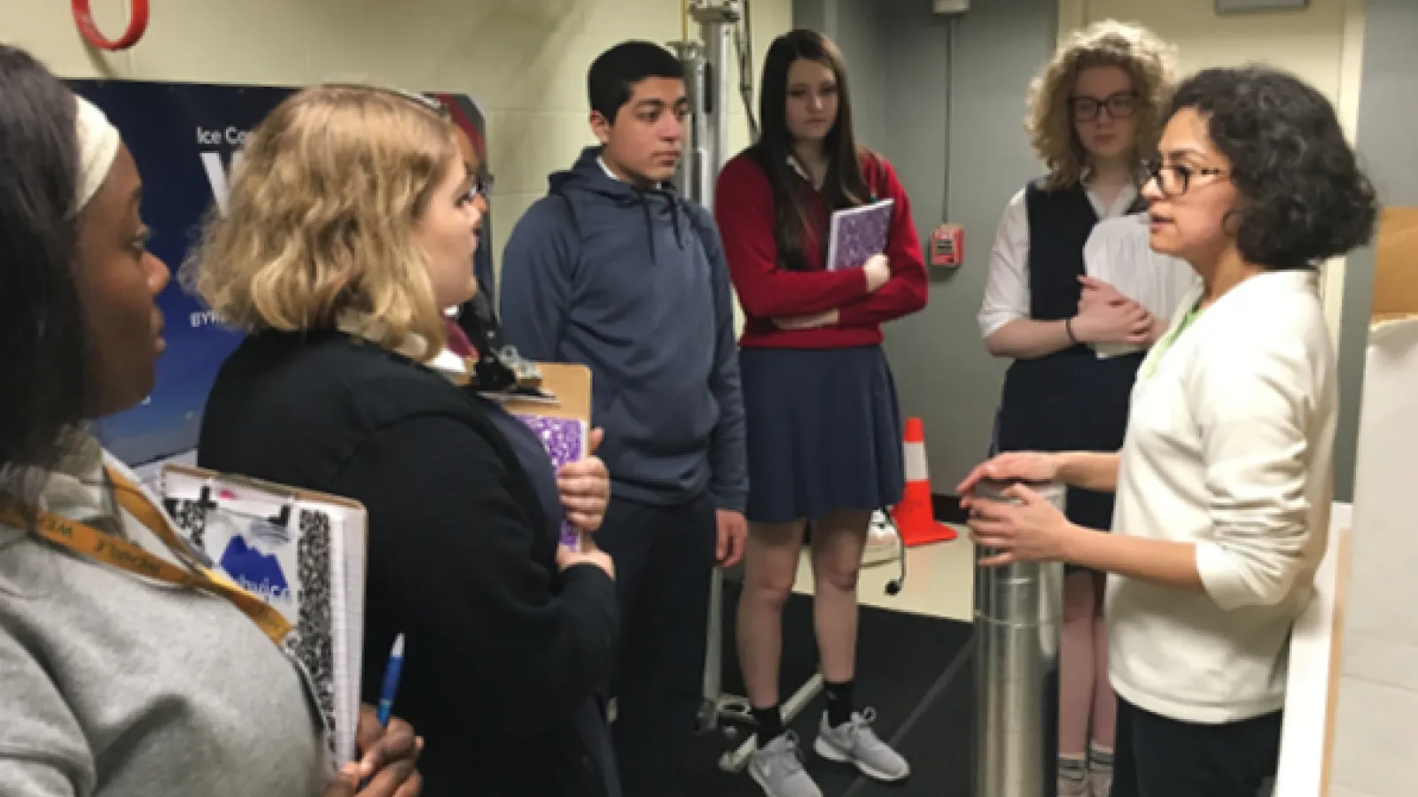Dr. Roxana Sierra-Hernández stands in front of a group of students, showing them an ice core insulator.