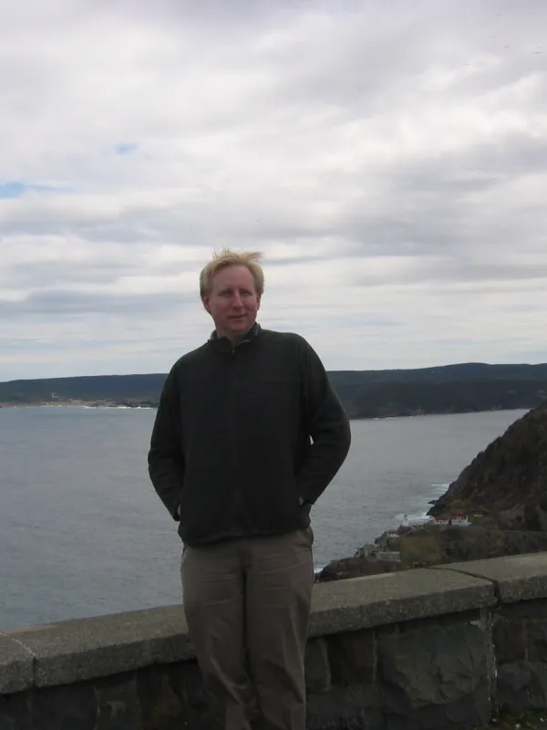 Keith Hines Standing in front of a lake with cloudy skies