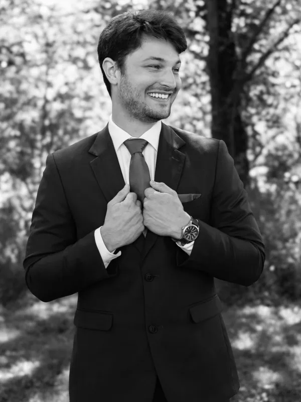 Austin smiling in a suit, black and white