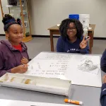 Three students sit around a table and learn about ice cores.